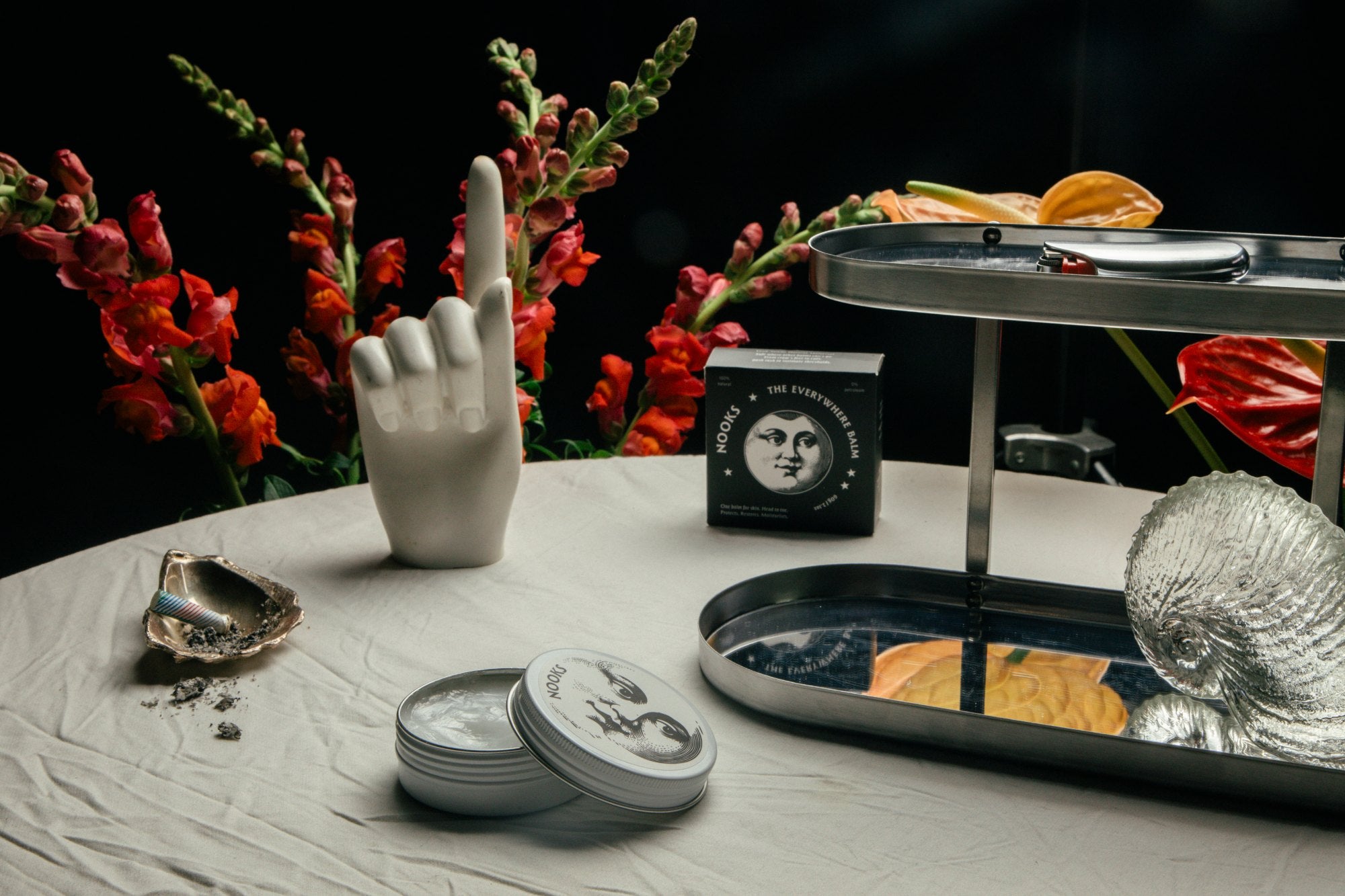 The Everywhere Balm tin in an apothecary still life