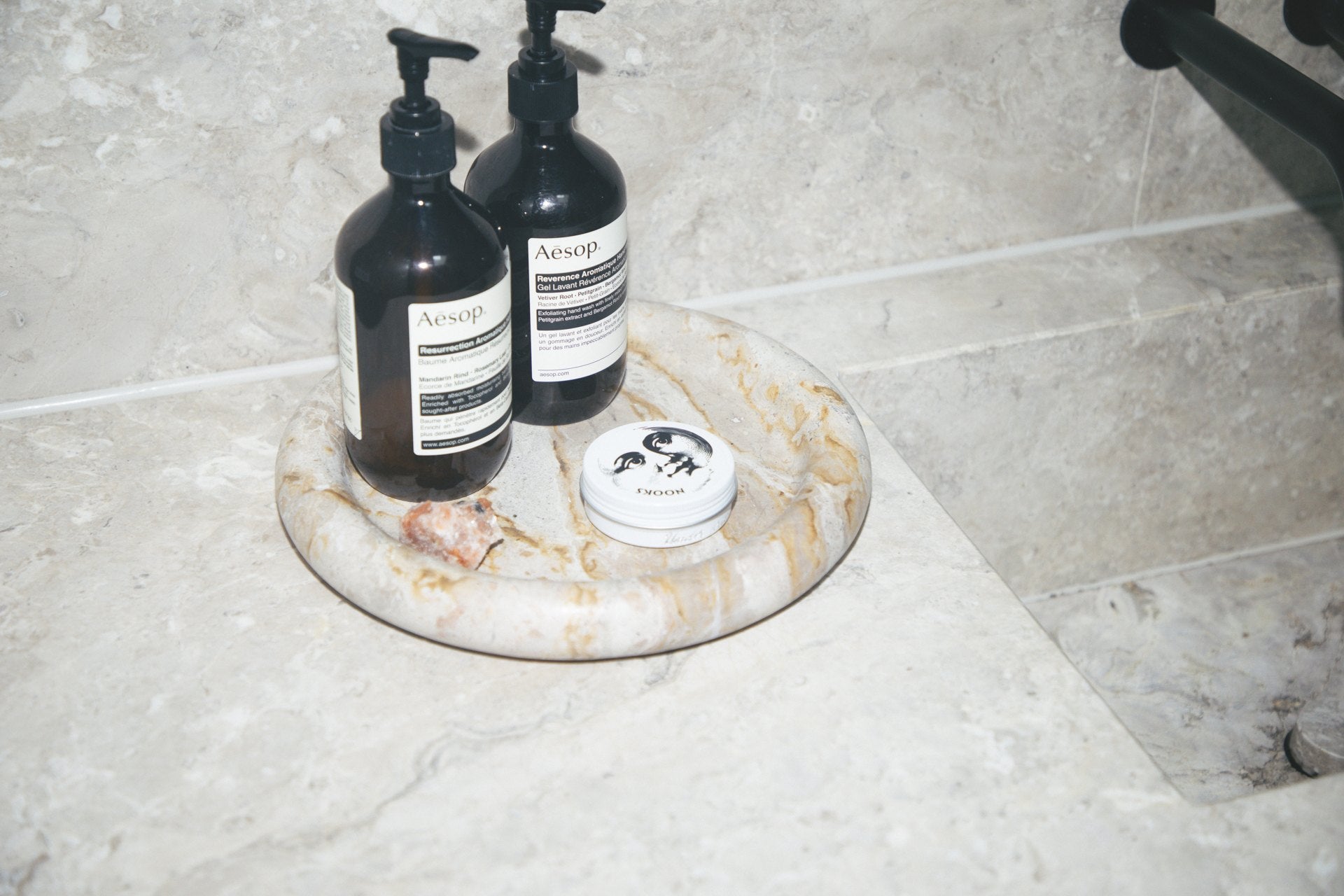 A bathroom shelf of half-used skincare products