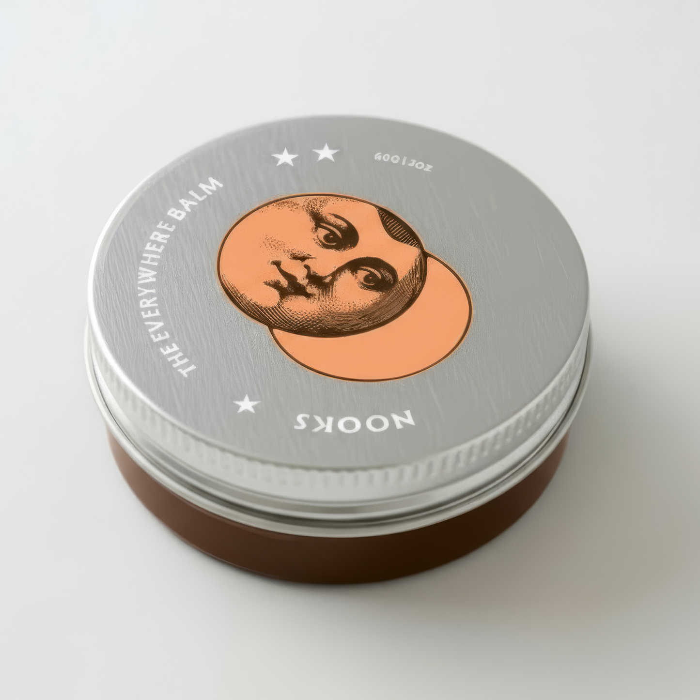 Metallic tin with a circular label featuring a moon face coral eclipse
