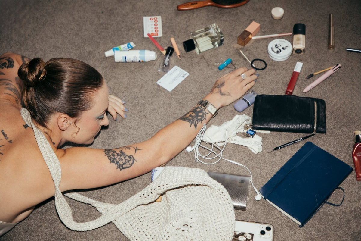 The contents of a handbag spilled on carpet, one Nooks tin among them